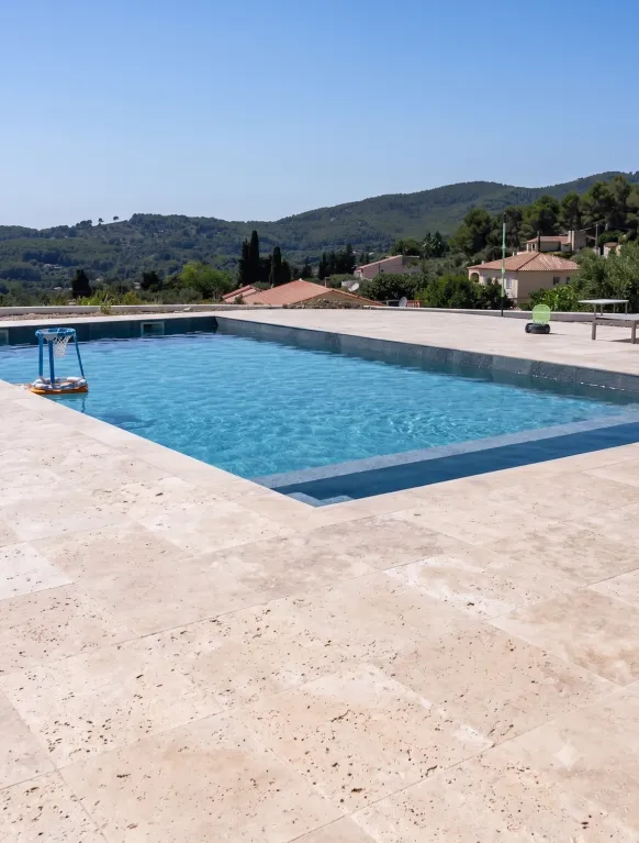 Terrasse et plage de piscine en travertin à Saint-Tropez par MDC Rénovation